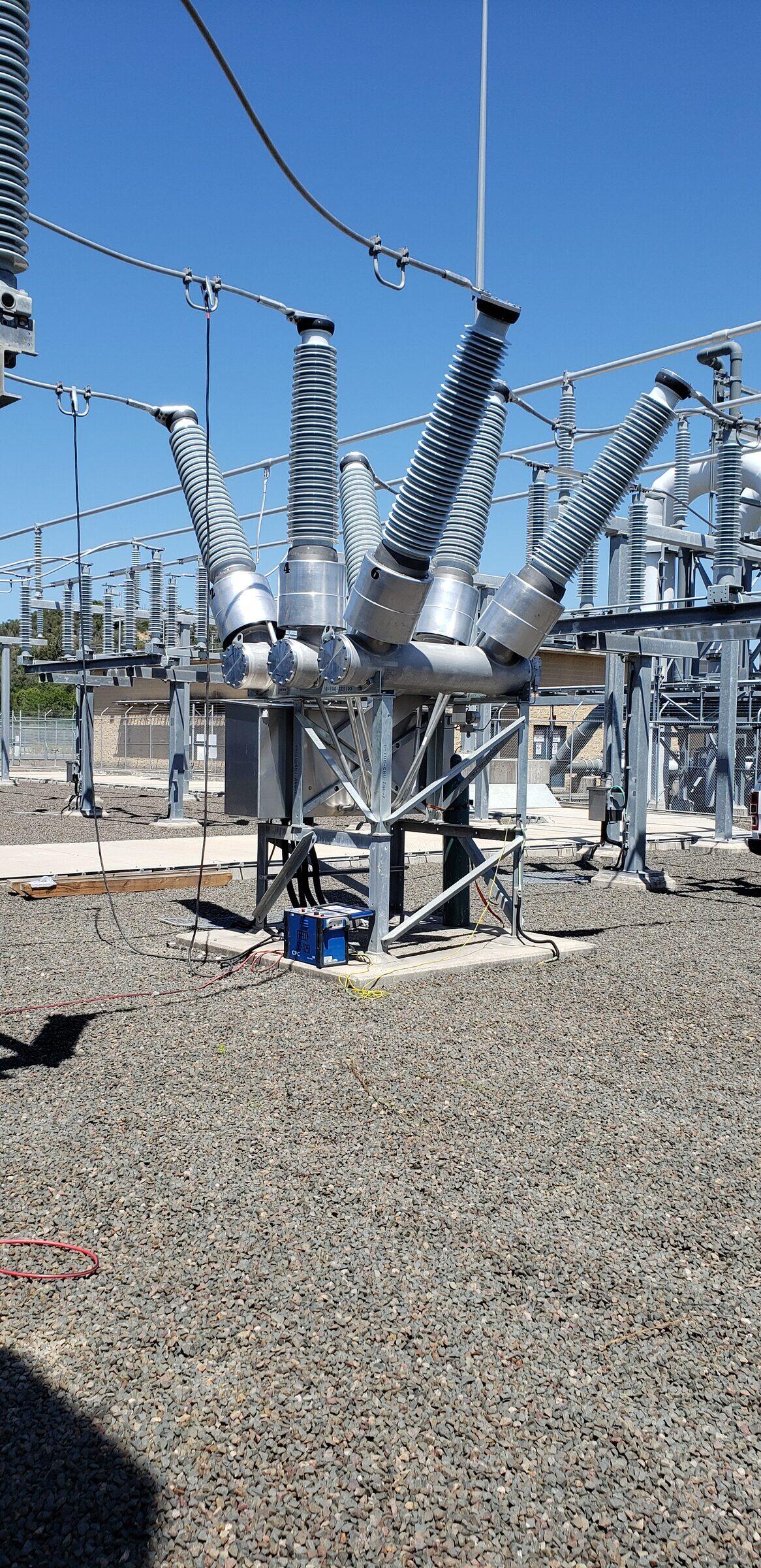 A high voltage disconnector and surge arresters mounted on a switchyard structure