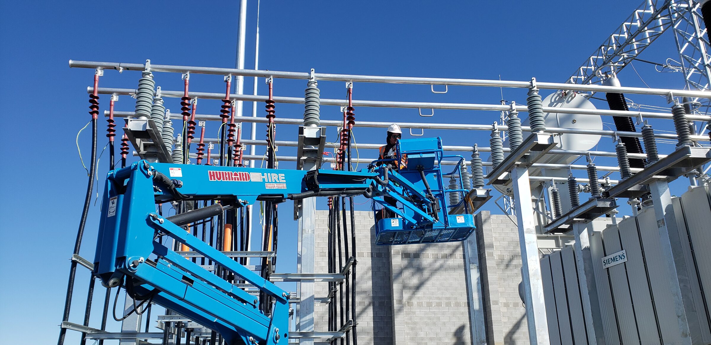 A Nebula crew working from an elevated platform on switchyard steelwork