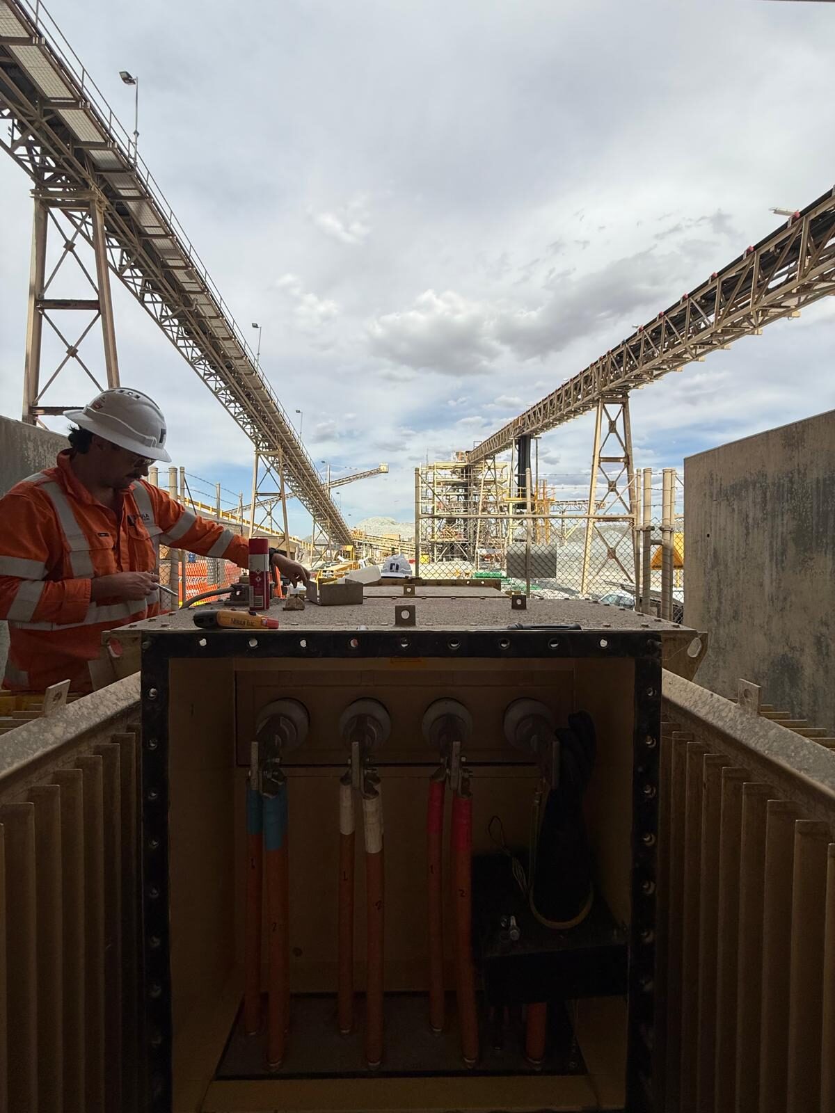 A Nebula electrician working at a panel on a large steel structure