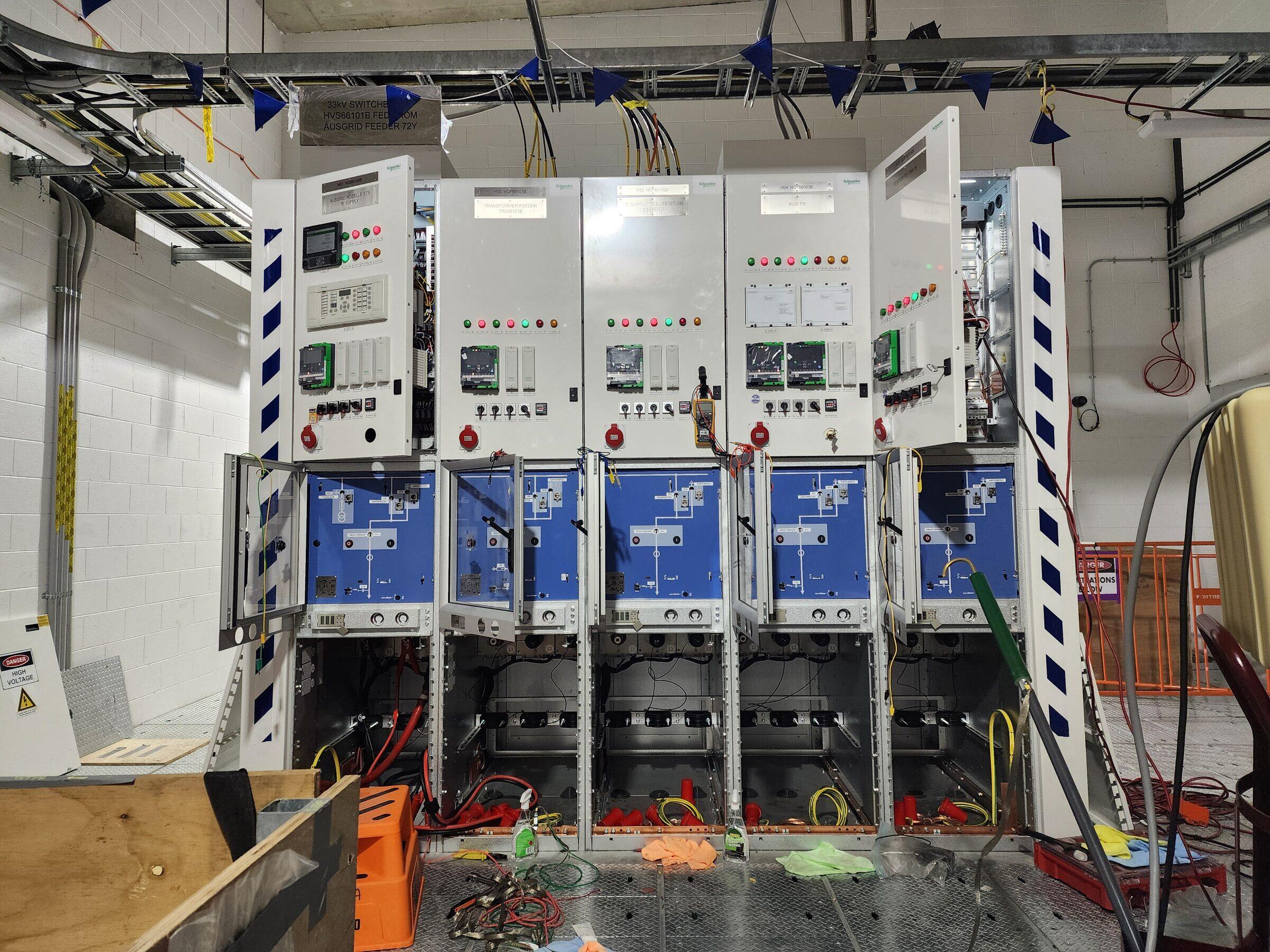 A rack of protection relays with test leads connected during commissioning