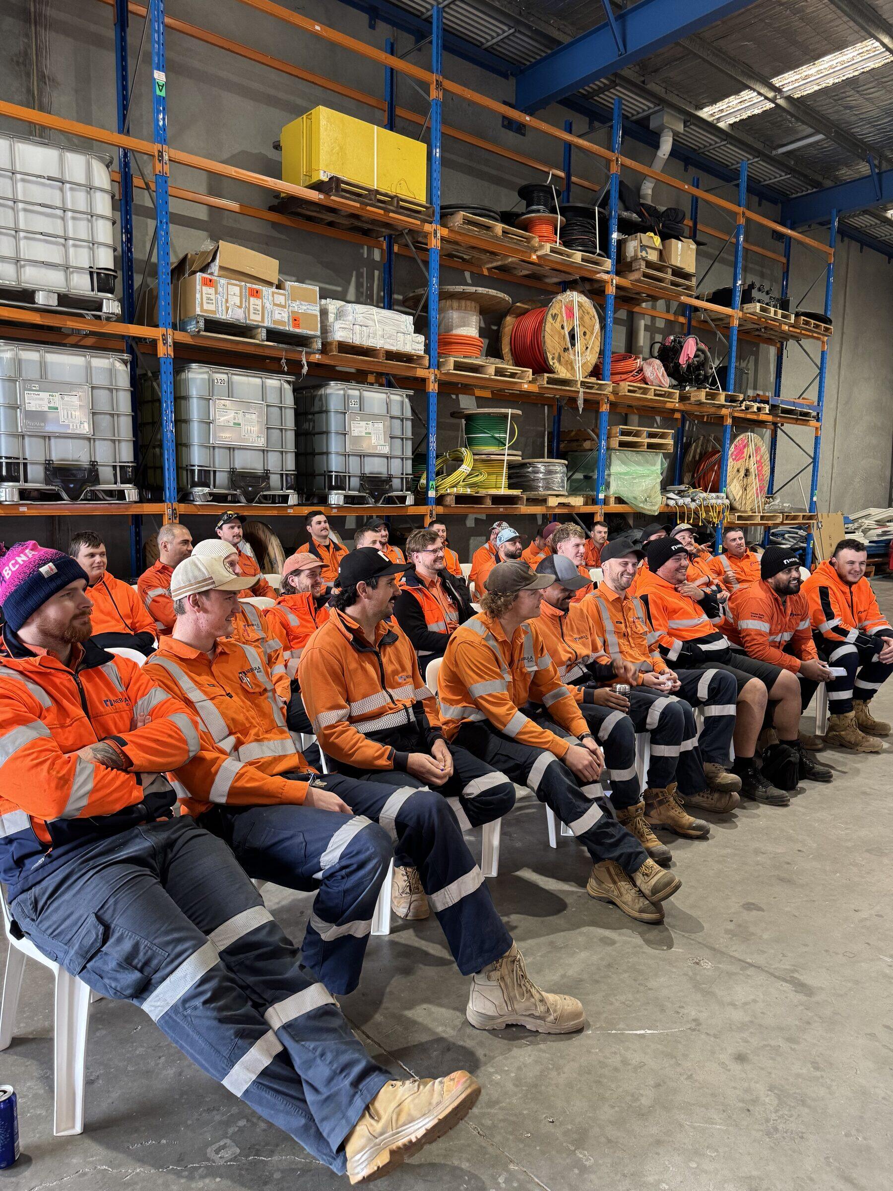 A full room of Nebula crew seated for a training session in the workshop